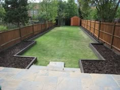 a backyard with grass and wooden fenced in area