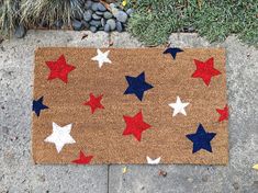 a person standing next to a door mat with red, white and blue stars on it