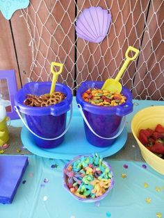 two buckets filled with cereal sitting on top of a table