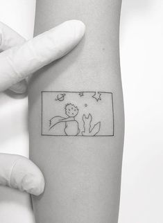 a person holding their arm with a small tattoo on the left side of her arm