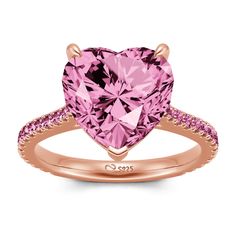 a pink heart shaped ring with diamonds on the band and side stones in rose gold