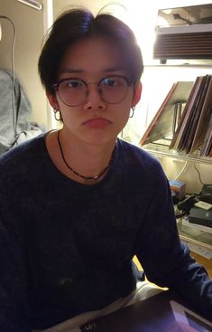 a woman wearing glasses sitting in front of a laptop computer