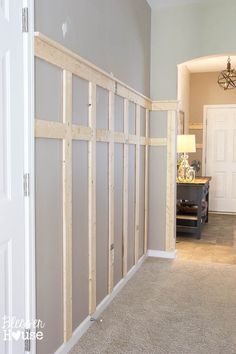 a room that is being remodeled with some wood framing on the wall and carpeted floor