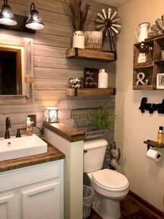 the bathroom is decorated in rustic style with wood accents and shelving above the toilet