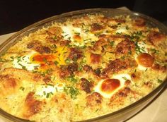 a casserole dish with eggs and cheese on it sitting on top of a table