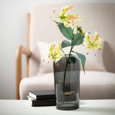 a vase filled with yellow flowers sitting on top of a table next to a book