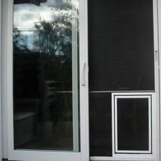 an open sliding glass door with black roller shades on the outside, and white trim around the windows