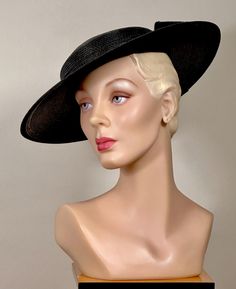 Description  A ca50s woven rayon wide brim black hat with a self hat and with a bow on the back. The thickness of the woven rayon is substantial and the hat never goes out of shape.  The woven rayon bow and hatband inside and out are edged in black rayon ribbon. The hat has a shiny finish. The hat sits on the top of the crown at an elegant angle, and will need a hat pin or elastic to keep it in, and it should fit most.  in like-new condition.  No label.  An iconic and elegant 50s platter hat- a 1950s Hat, Women Hats, Elegant Hats, Black Polish, Hat Pin, Out Of Shape, Black Hat, 50s Fashion, Hat Band