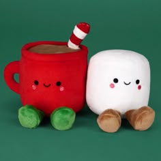 two marshmallows sitting next to each other on a green background with a red mug