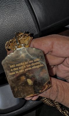 a person is holding a small metal object in their hand, with a quote on it