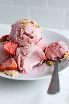 two scoops of ice cream and strawberries on a plate