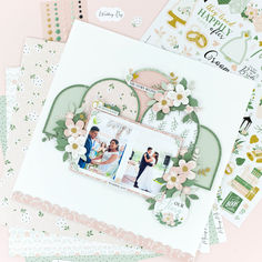 a scrapbook with flowers and photos on it, surrounded by other paper work items