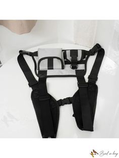 the back of a black and white baby carrier with straps attached to it's chest