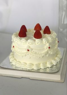 a cake with white frosting and strawberries on top