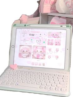 an open laptop computer sitting on top of a white desk next to a stuffed animal