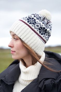 Wool is known for its excellent insulation properties, and it's a natural, sustainable material. This makes the hat both warm and eco-friendly. The hat's design is inspired by classic Estonian winter traditions, ensuring it retains warmth and keeps you comfortable in cold weather. Features a pompom. - 100% wool - Unisex -  Winter jacquard SKU CODE:  VM-117 White Winter Hats For Cold Weather, Warm Winter Bonnet With Curved Brim, Warm Nordic Hats For Outdoor, Cream Winter Hats For Cold Weather, Outdoor White Knitted Hats, Nordic Style Warm Outdoor Hats, Warm Nordic Beanie For Outdoor, Cream Cap For Cold Weather, Nordic Warm Hats For Cold Weather