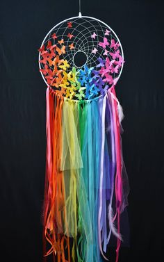 a multicolored dream catcher hanging on a black background