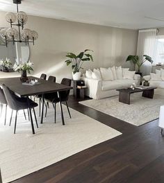 a living room filled with furniture and a dining table in front of a large window