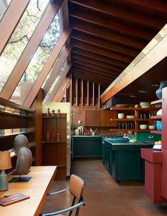 an open kitchen and dining area in a house with wooden ceilings, wood flooring and exposed beams