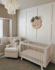 a baby's room with a crib, chair and couch in the corner