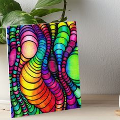 a colorful abstract painting on a white background art boarder next to a potted plant