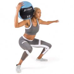 a woman holding a medicine ball in one hand and her other arm out to the side