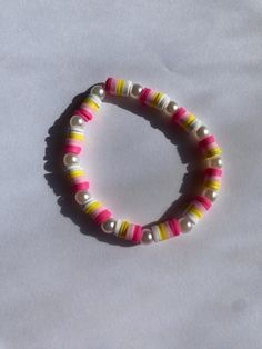 This is such a cute summer bracelet! It has pearls and pink and yellow beads perfect for when beside the pool or beach! Colorful Beaded Yellow Bracelets For Vacation, Yellow Beaded Bracelet For Vacation, Yellow Bracelets With Round Beads For Vacation, Summer Pearl Beaded Bracelets For Beach, Yellow Beaded Bracelets For Vacation, Pink Stretch Bracelet With Letter Beads For Vacation, Fun Yellow Beaded Bracelet For Summer, Fun Yellow Beaded Bracelets For Summer, Multicolor Pearl Bracelet For Summer Beach