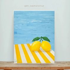 a painting of two lemons on a yellow and white striped table with blue water in the background