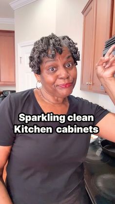 a woman standing in front of a stove top oven with the words sparkling clean kitchen cabinets