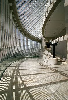 the inside of a building with many windows and light coming in from it's ceiling