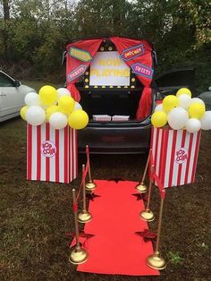 the back of a car is decorated with popcorn boxes and balloons for an outdoor movie party