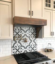 a stove top oven sitting inside of a kitchen next to white cabinets and counter tops