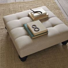 a small ottoman with books on it