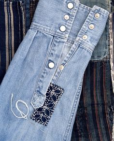 two pairs of jeans with buttons on them