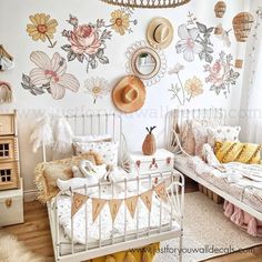 a room with two beds and a basket hanging from the ceiling above it, decorated with flowers