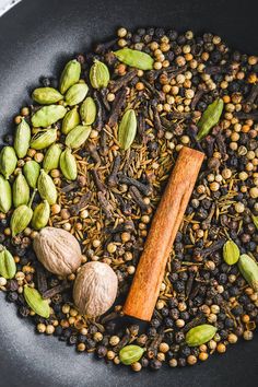 an assortment of spices and nuts in a wok on top of some kind of table