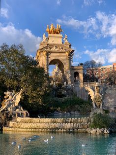 the fountain is surrounded by statues and birds