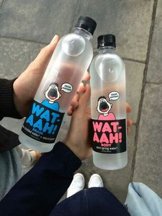 two people holding water bottles with cartoon stickers on them