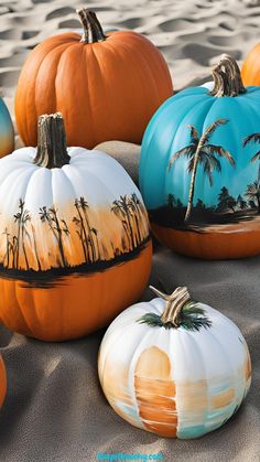 painted pumpkins sitting in the sand with palm trees on them