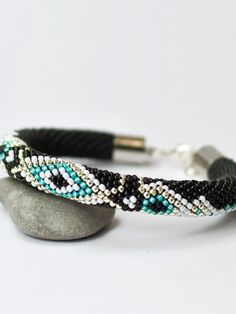 a beaded bracelet sitting on top of a rock