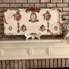 a white mantle with a clock and figurines on it next to a brick wall