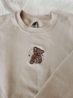 Introducing our Honey Bear Embroidered Sweatshirt 2D Crewneck Sweatshirt, a versatile and stylish clothing option for both women and men. This sweatshirt is designed to provide utmost comfort while making a fashion statement. Our Honey Bear Embroidered Sweatshirt features a unique 2D design, showcasing a charming honey bear embroidery on the front. This eye-catching detail adds a touch of playfulness and personality to your outfit, making you stand out from the crowd. Quality is our utmost prior Clothes Embroidery Diy, Bear Sweatshirt, Embroidery Hoodie, Honey Bear, Embroidery On Clothes, Embroidery Sweatshirt, Sweatshirt For Women, Shirt Embroidery, Embroidered Sweater