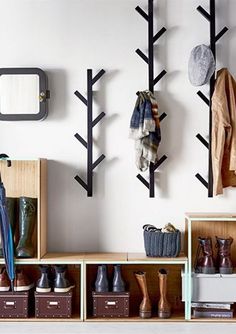 there is a coat rack with shoes and umbrellas hanging on the wall next to it