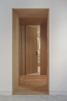 an open wooden door in a white room