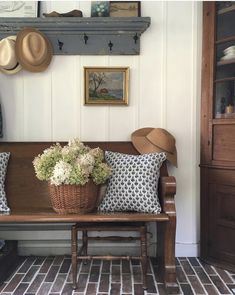 a wooden bench sitting next to a wall with hats on top of it's head