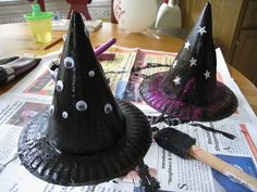 two black witches hats sitting on top of a table next to a pile of papers