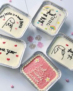 four tins filled with white frosting on top of a table next to confetti