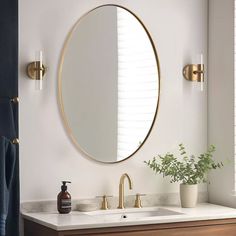 a bathroom sink with a round mirror above it and a vase on the counter next to it