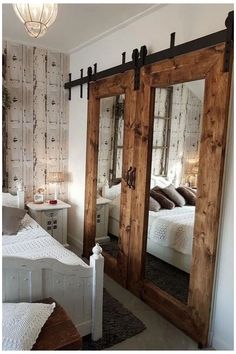 a bedroom with two mirrored doors and a white bed in it's center area