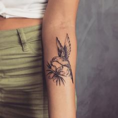 a woman with a bird tattoo on her arm